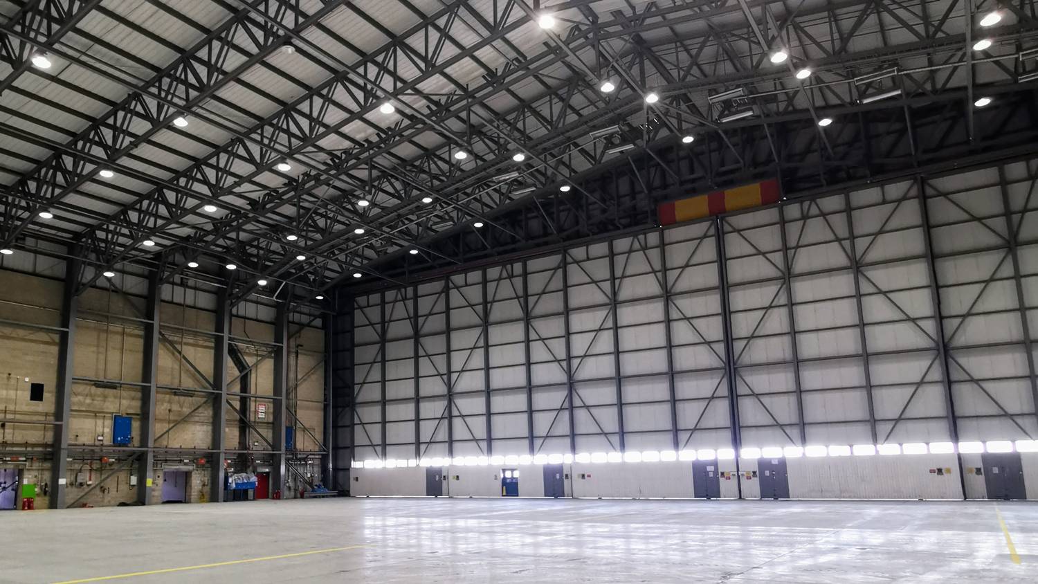 Aircraft hangar interior at Gatwick with airless-sprayed structural steel roof trusses – Fixidea Coatings Ltd