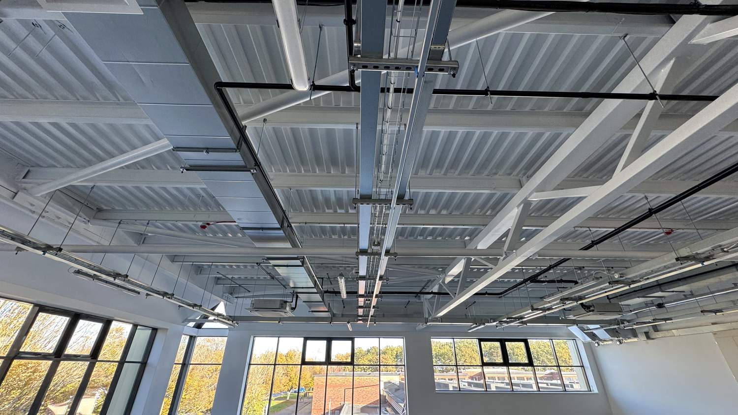 Open-plan ceiling, steelwork and exposed services spray-painted white – Fixidea Coatings Ltd