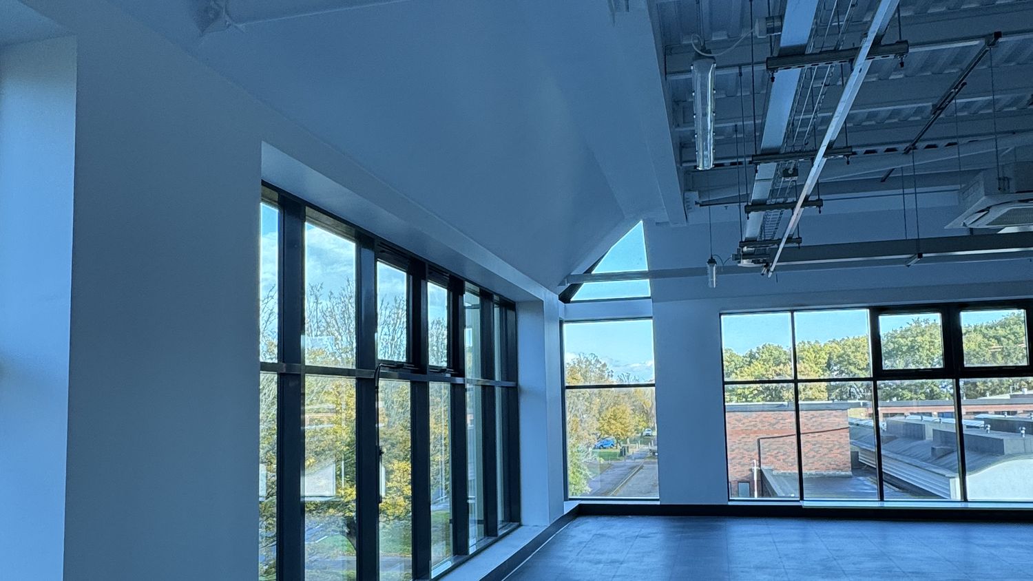 Open-plan office with spray-finished walls and exposed ceiling, Manor Royal, Crawley – Fixidea Coatings Ltd