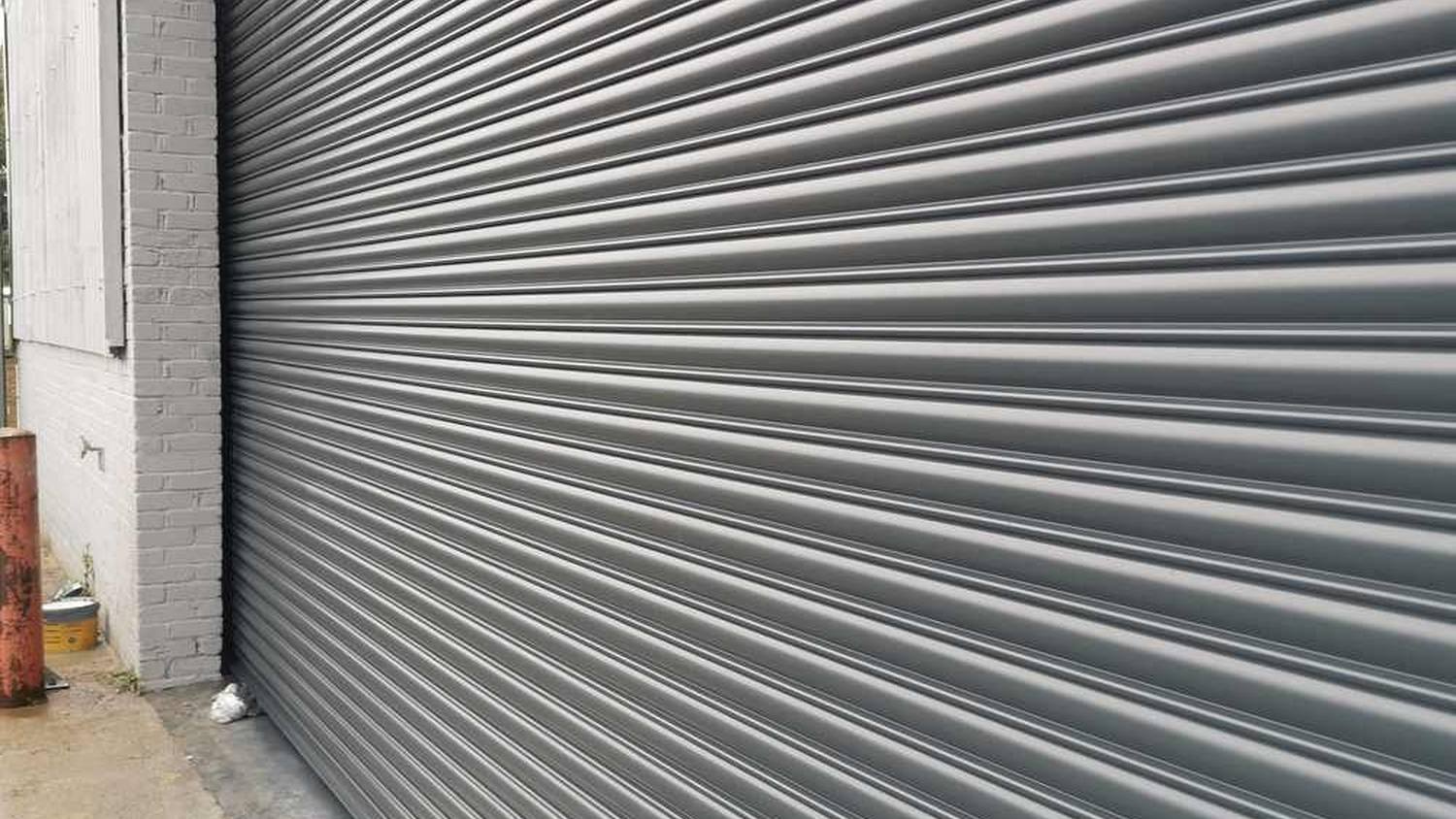 Industrial roller shutter resprayed on site in RAL grey – Fixidea Coatings Ltd
